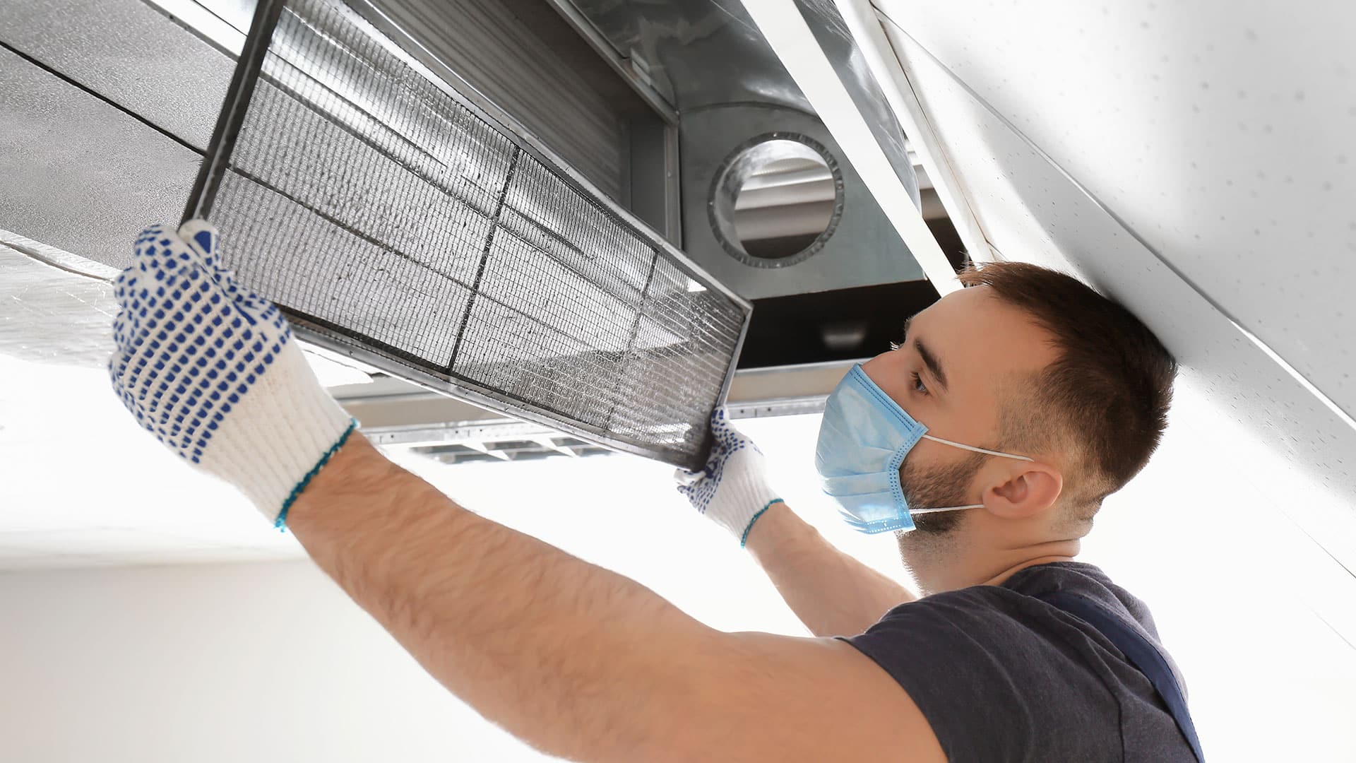 Boiler repair technician performing an air duct cleaning