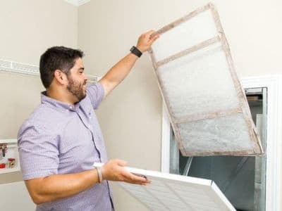 homeowner changing air filter in home